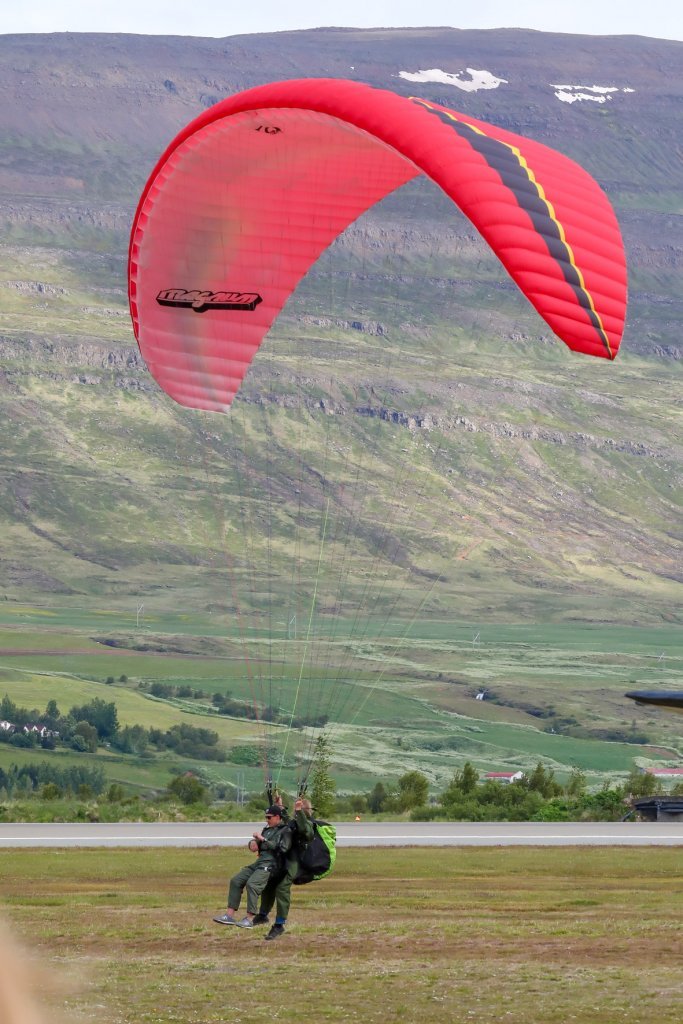 Svifvængja með farþega, sem var dregin upp af bíl á flugbrautinni